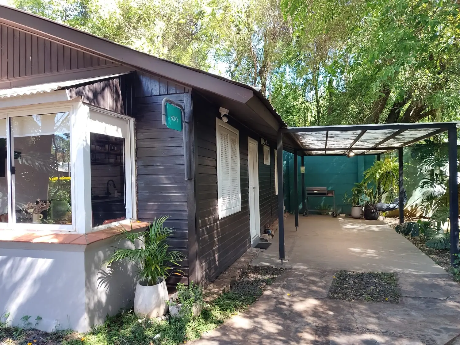 Fachada diurna y cochera cubierta de HOVY en La Aventura